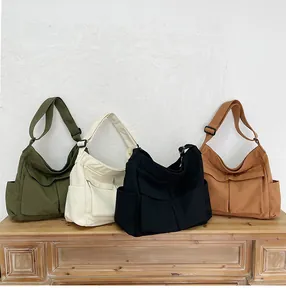 Collezione di borse a tracolla in tela capienti in verde militare, beige, nero e marrone