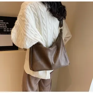Detail van de vintage donkerbruine shopper met matte textuur en de schouderriem