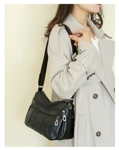 Close-up of black soft leather crossbody bag with multiple front zipper pockets for women