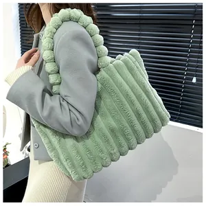 Détail du sac cabas en peluche vert clair avec texture verticale et bandoulière pompon