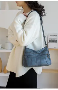 Detail view of the multi-zipper soft PU leather shoulder bag in vintage grey blue color