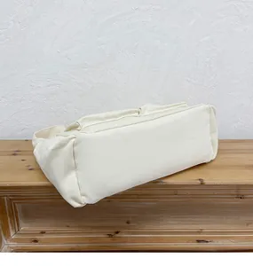 Dettaglio del fondo della borsa in tela color crema con cuciture robuste e ampia capienza