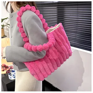 Détail du cabas en peluche rose vif avec texture matelassée et anse en boules de fourrure