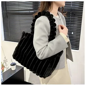 Gros plan d'un sac cabas noir en peluche avec textures en fausse fourrure et détails de billes