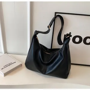 Detailopname van zwarte leren hobo-tas met gouden gesp en een soepele ritssluiting