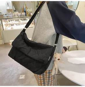 Detail van zwarte crossbodytas met hartstiksel en een schattige pluche beren-hanger