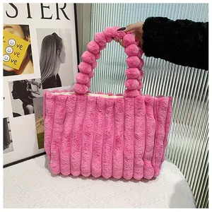 Gros plan du sac cabas en fausse fourrure rose vif avec poignées bulles et texture rayée