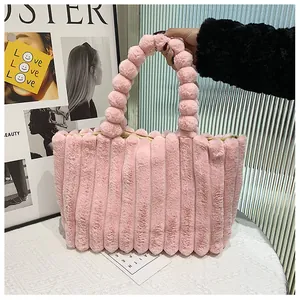Détail du sac à main rose en peluche avec poignées bulles et texture rayée douce