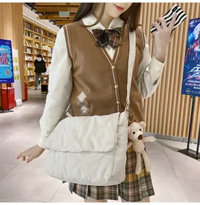 Detailopname van witte crossbodytas met hartstiksel en een schattige pluche beer