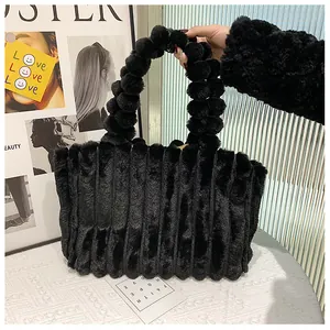 Détail du sac à main noir en peluche avec poignée en boules et texture plissée