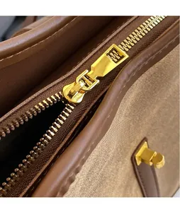 Makro-Detail von glänzendem Gold-Reißverschluss und Nähten an der Segeltuchtasche