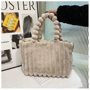 Détail du sac cabas en peluche beige avec texture rayée et poignée en boules de poils