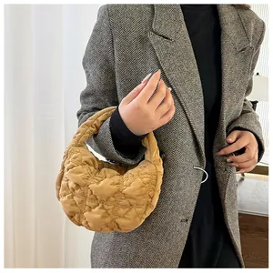 Detail van de camel gewatteerde mini handtas met zachte textuur en geplooid design