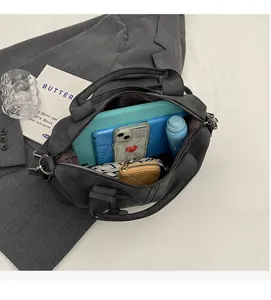 Draufsicht der großen dunkelgrauen Boston-Tasche mit Tablet, Handy und täglichen Utensilien