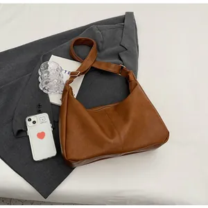 Detail van vintage karamelbruine hobo tas met leertextuur en verstelbare schouderriem