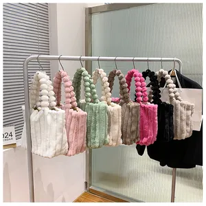 Détail de sacs fourre-tout en peluche colorés avec poignées à pompons pour l'automne et l'hiver