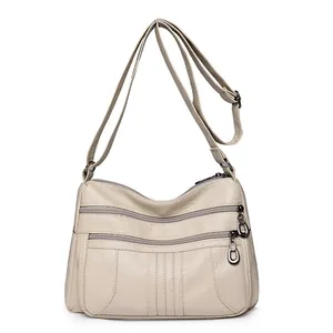 Creamy beige soft leather shoulder bag with multi-layer zippers and pebbled texture