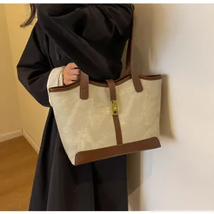 Detailansicht der großen Canvas-Tasche mit braunem Lederbesatz und Drehverschluss
