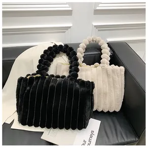 Vue détaillée de sacs cabas en peluche avec texture verticale et poignées à boules