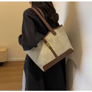Seitenansicht einer Vintage-Canvas-Tasche mit braunem Lederbesatz an einem Model