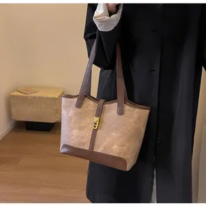 Nahaufnahme der Retro-Contrast-Tote-Bag mit goldener Metallschnalle und braunen Ledergriffen