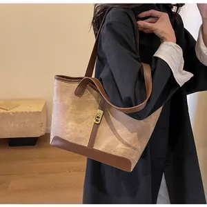 Detailansicht der zweifarbigen Shopper-Tasche mit Goldschloss und Lederriemen am Model