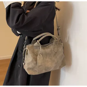 Dunkelgraue Vintage Boston Tasche mit verstellbarem Riemen getragen zum Mantel