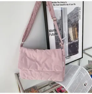 Detailopname van de roze gewatteerde schoudertas met hartpatroon en brede riem