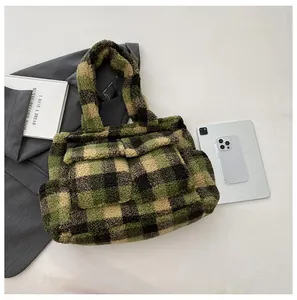 Detail of plaid fleece tote bag with front pocket showing soft lamb wool texture