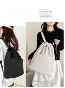 Dual view of black and beige nylon drawstring backpacks with large front pocket