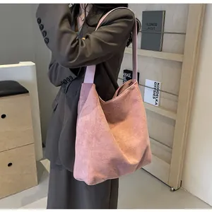 Rosa große Hobo-Tasche aus Wildleder-Textur mit breitem Schultergurt auf Modellseite