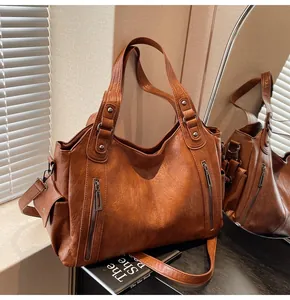 Detailed view of dark brown vintage oil-wax leather tote bag with bronze zippers