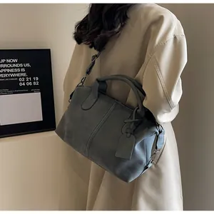 Detail der mattgrauen Boston-Tasche mit glatten Reißverschlüssen und verstellbarem Riemen