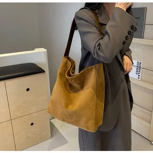 Detailansicht der dunkelbraunen Wildleder-Tragetasche mit breitem Schultergurt im Hobo-Stil