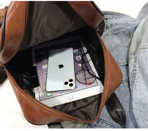 Detailed view of the spacious brown leather backpack interior with tablet and phone