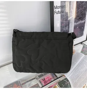 Detail van zwarte crossbody tas met groot hartvormig gewatteerd patroon van ruimtekatoen