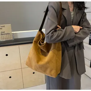Detail of camel suede tote bag showing the wide strap and spacious retro hobo design