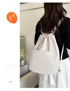 Detail of light pink drawstring nylon backpack with large front pocket on female model