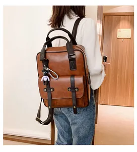 Macro shot of brown faux leather backpack texture with strap detail and bear charm