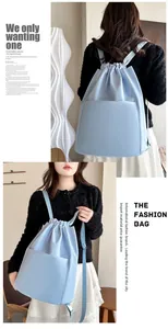 Detail of light blue nylon drawstring backpack with front pocket for travel and yoga