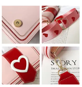 Dettaglio della fibbia dorata a cuore e ricamo a onde sulla borsa in pelle rosa