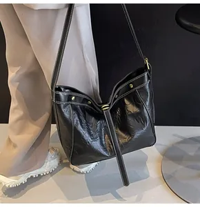 Detail of black PU leather tote with white contrast stitching and metallic rivets
