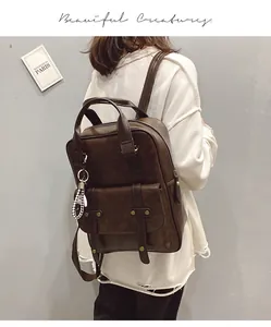 Detail of vintage brown leather backpack with buckle straps and checkered charm accessory