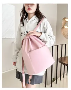 Close-up of pink drawstring nylon backpack featuring smooth texture and front pocket
