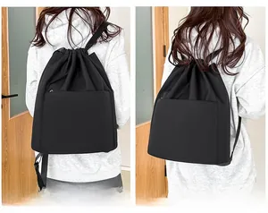 Detail view of black drawstring nylon backpack with high-density waterproof fabric and zipper pocket