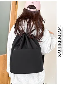 Detail of black nylon drawstring backpack with smooth finish and hidden front zipper pocket