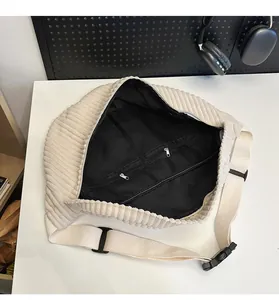 Detailed top view of off-white corduroy bag interior with mesh lining and dual zip pockets