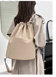 Close-up of beige nylon drawstring backpack with large front pocket for yoga and travel