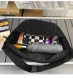 Detailed interior of black woven chest bag showing storage for umbrella and phone