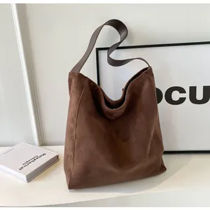 Macro detail of brown suede tote bag featuring premium matte texture and wide shoulder strap